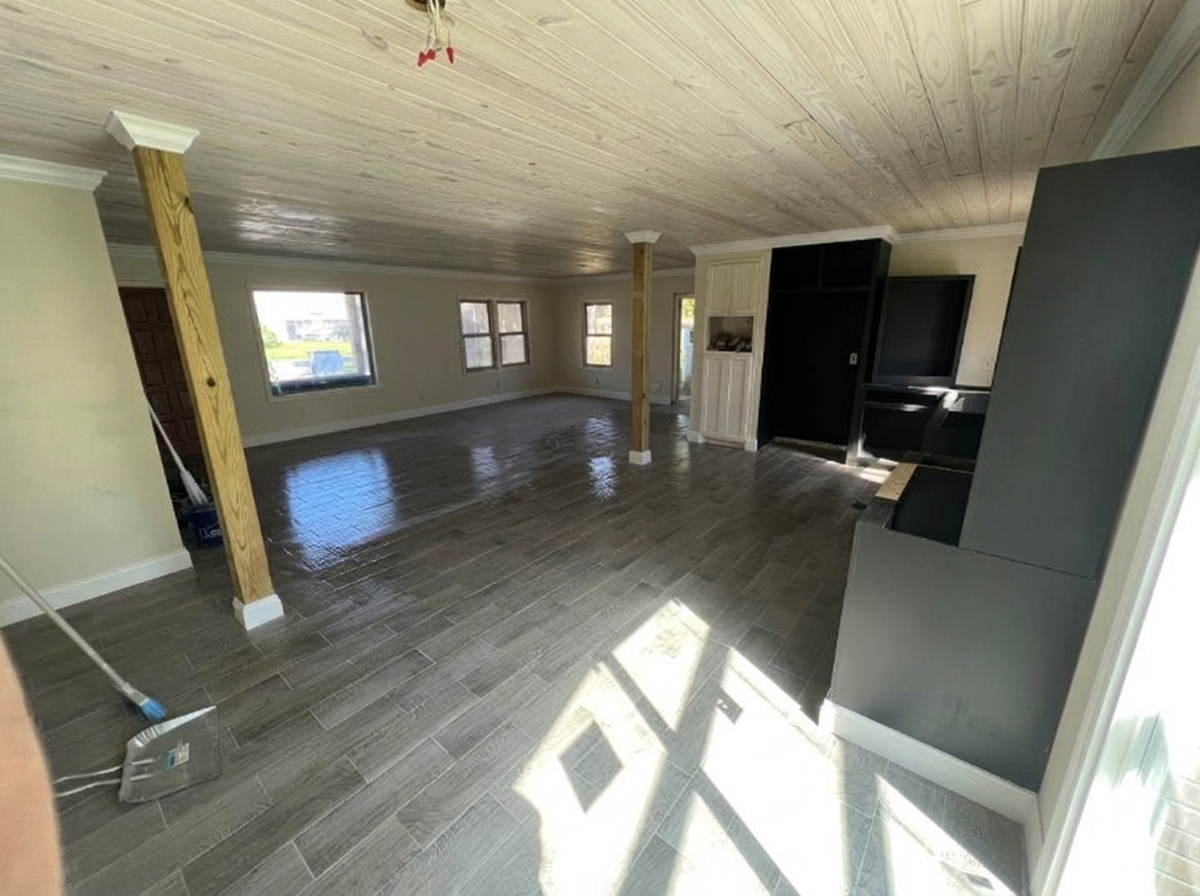 After — finished Waverly GA living room and kitchen remodel Finished open living room and kitchen in Waverly GA with wood plank ceiling, white baseboard and crown molding, and new wood-look plank flooring